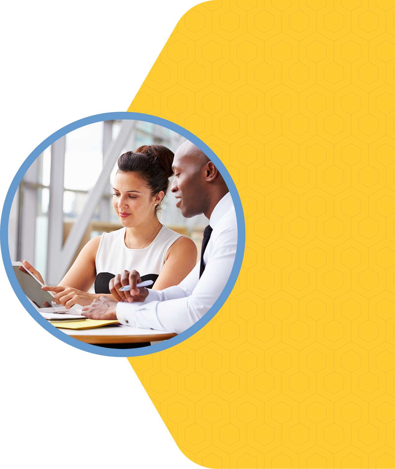 A man and woman sitting at a table with a tablet.